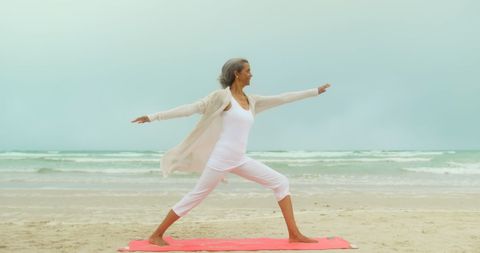 Active Senior Woman Practicing Yoga on Tranquil Beach - Download Free Stock Images Pikwizard.com