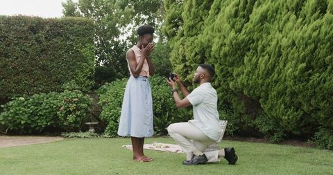 Man Proposing to Woman in Scenic Garden Environment