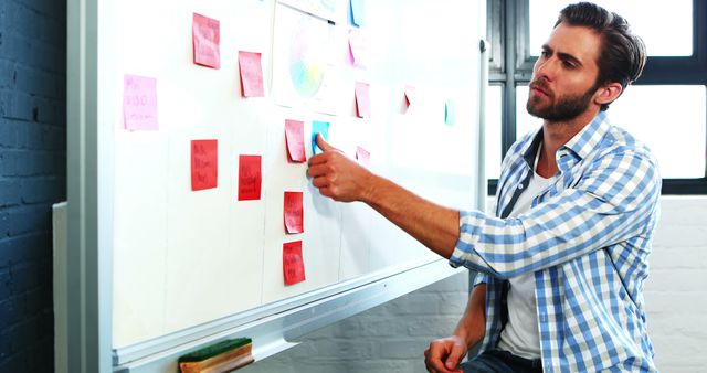 Focused Businessman Using Sticky Notes on Whiteboard - Download Free Stock Images Pikwizard.com