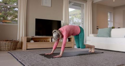 Senior Woman Practicing Yoga at Home Improving Flexibility and Balance