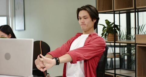 Office worker stretching at desk for ergonomic break