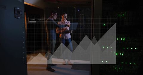 Colleagues analyzing data graph in server room