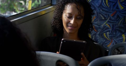 Smiling Woman Using Tablet During Bus Commute
