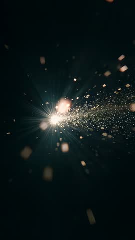 Vertical starburst spark trail emitting glittering particles with lens flare and cinematic bokeh
