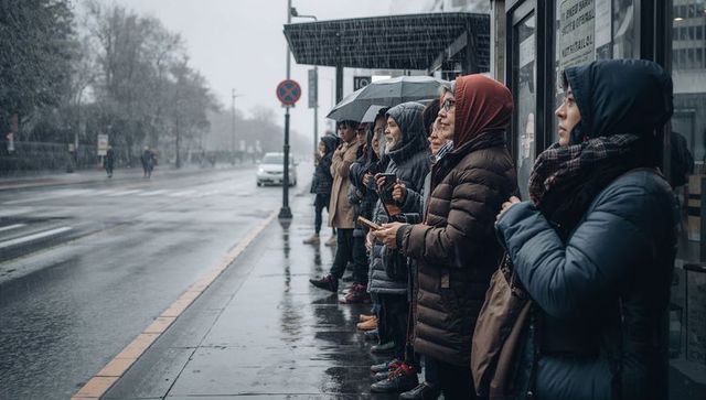 Waiting commuters wearing hijab holding umbrellas at rainy urban bus shelter