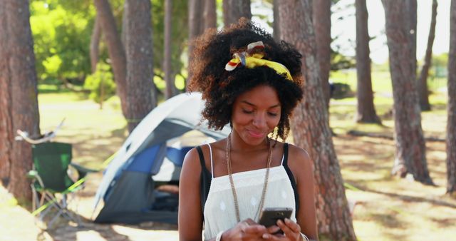 Young Woman Texting On Mobile Phone During Camping Trip In Woods - Download Free Stock Images Pikwizard.com