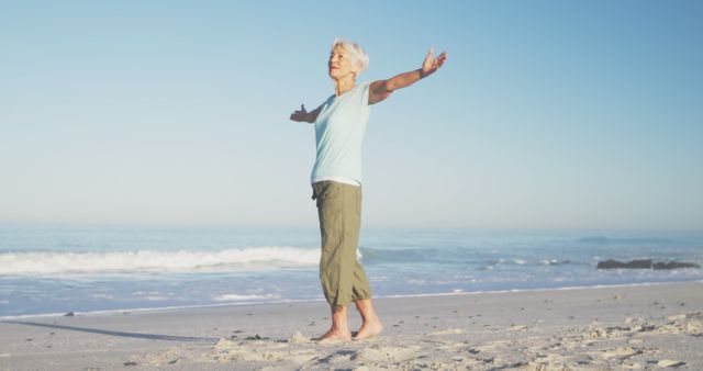 Happy senior caucasian woman smiling and widening arms on beach - Download Free Stock Photos Pikwizard.com