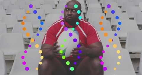 Rugby player sitting on empty stadium seats holding ball with colorful hexagon overlay