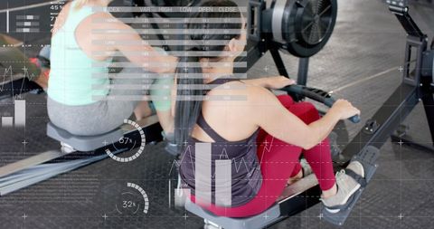 Women training on rowing machines with digital interface overlay
