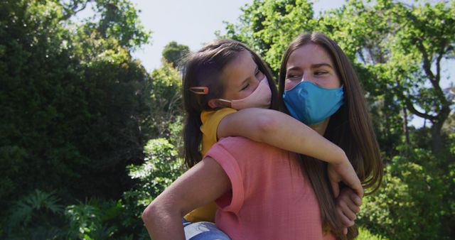 Mother Carrying Daughter Outdoors Both Wearing Face Masks - Download Free Stock Images Pikwizard.com