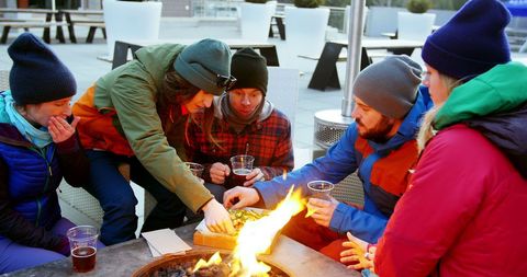 Young adults enjoy cozy outdoor gathering by fire pit