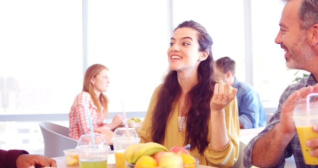 Group of friends enjoying drinks and fruits while chatting in a casual, relaxed cafe setting. Perfect for illustrating concepts of friendship, community, and relaxation. Could be used for advertisements, social media, or hospitality industry marketing.