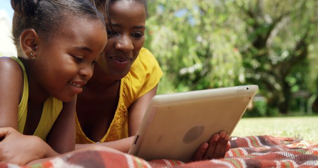 Mother and Daughter Reading Tablet in Park Together - Download Free Stock Images Pikwizard.com