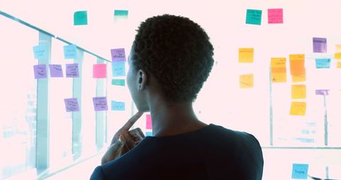 Professional Contemplating Sticky Notes on Glass Wall - Download Free Stock Images Pikwizard.com
