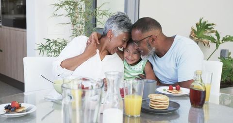 Elderly Couple Enjoying Breakfast with Grandchild in Kitchen