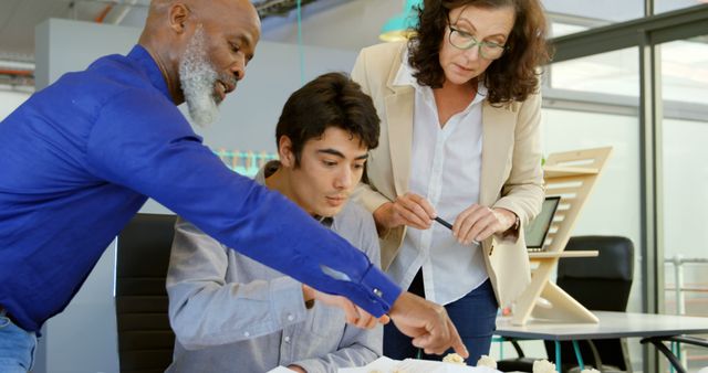 Mentors guiding young man in modern office setting - Download Free Stock Images Pikwizard.com