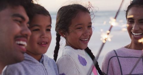Joyful Family with Sparklers on Beach at Sunset