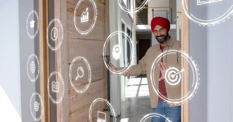 Man wearing red turban interacting with augmented reality icons at modern home entrance