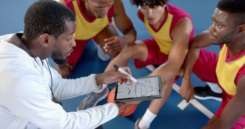 Basketball coach discussing strategy with concentrated team