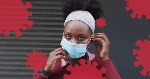 Young woman adjusting surgical mask outdoors with red virus overlays, urban health safety
