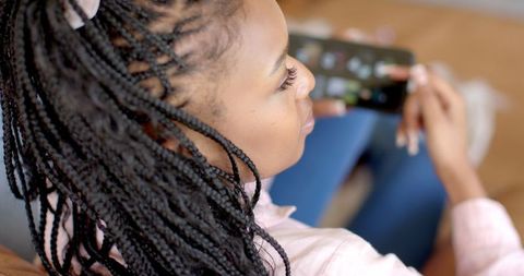 Young Woman with Braided Hair Using Smartphone Indoors