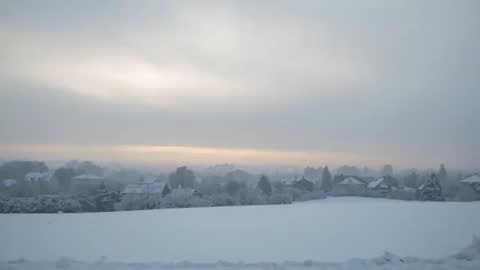 Sunrise Breaking Over Snow-Covered Village, Bathing Open Field in Soft Morning Light