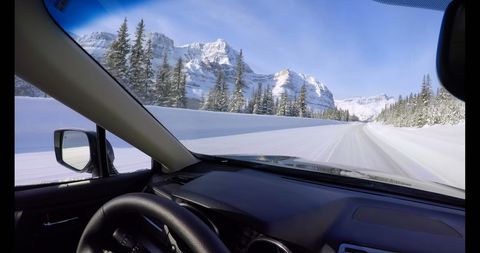 Driving Through Snowy Mountain Roads with Scenic Views