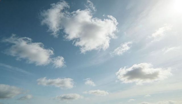 Sunlit Blue Sky with Fluffy Cumulus Cluster and Wispy Cirrus Streaks Near Horizon