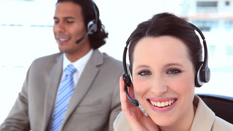 Smiling Business Professionals Using Headsets in Office