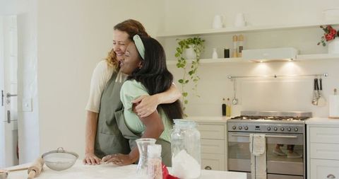 Mother Hugging Daughter in Cozy Kitchen During Baking Activity