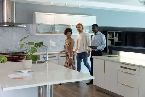 Real Estate Agent Showing Modern Kitchen to Prospective Buyers