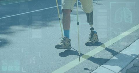 Man with prosthetic leg walking with trekking poles on road adventure