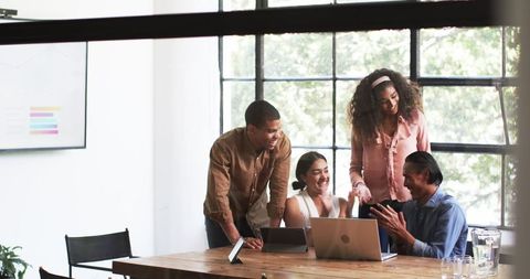 Diverse Team Celebrating Success in Collaborative Office Meeting