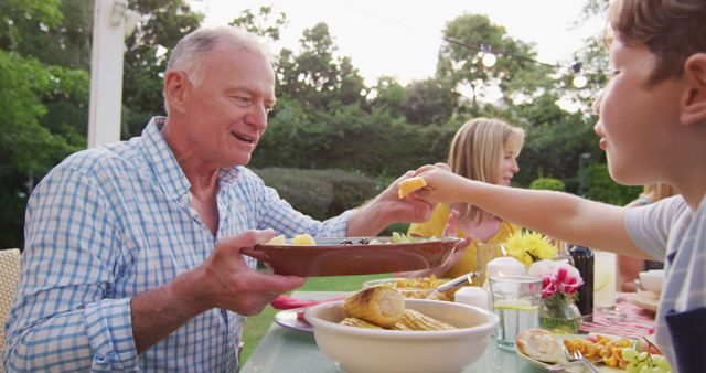 Grandfather Enjoying Outdoor Family Meal at Garden Dining Table - Download Free Stock Images Pikwizard.com