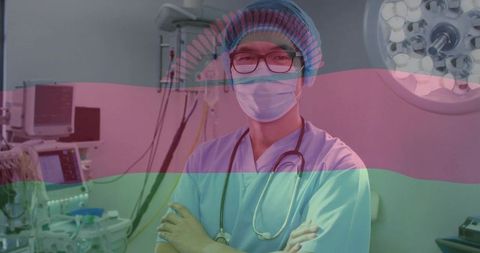 Standing clinician crossing arms in operating room wearing mask stethoscope glasses