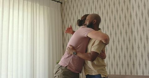 Two Men Sharing Warm Embrace in Cozy Living Room