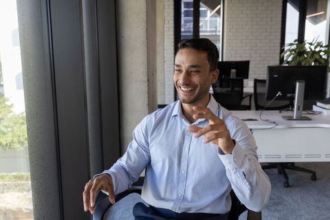 Cheerful Man Engaging in Conversation in Modern Office