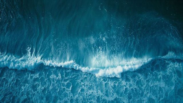 Dynamic ocean waves crashing in aerial coastal view