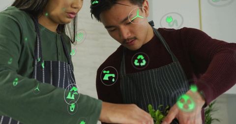 Asian Team Planting Green Seedlings with Eco Icons for Sustainability Concept