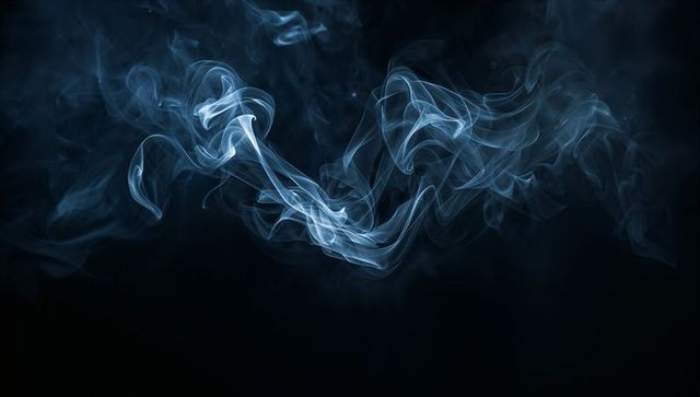 Ethereal blue smoke ribbons floating over deep black space for abstract graphic projects