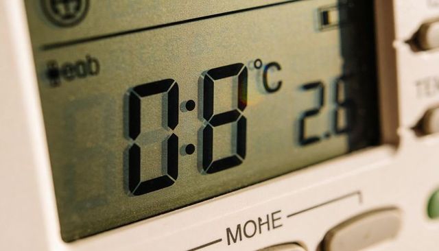 Macro close-up of digital thermostat displaying temperature on seven-segment lcd panel
