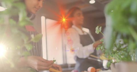 Mother and daughter cooking together with fresh herbs in kitchen