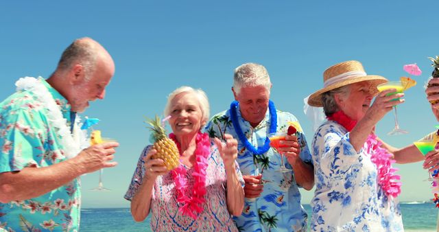 Group of senior friends celebrating at a beach party with Hawaiian theme. They are enjoying cocktails, wearing leis, and smiling under a bright sky. Ideal for use in lifestyle, vacation promotion, senior activities, celebration themes, and advertising related to retirement and leisure.