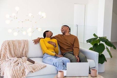 Couple Sharing Cozy Moment on Sofa with Laptop