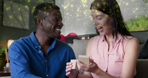 Couple exchanging jewelry surprise, woman opening ring box, smiling man celebrating love