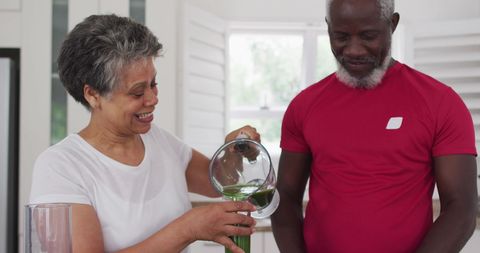 Couple Enjoying Healthy Lifestyle with Smoothie at Home Kitchen