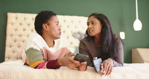 Diverse Female Friends Connecting in Cozy Bedroom Setting