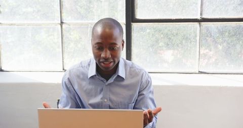 Business Professional Using Laptop at Modern Office Desk by Window