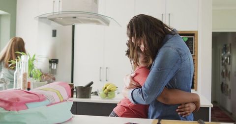 Mother Embracing Daughter in Kitchen for Quality Time