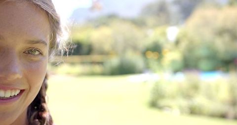Joyful Woman Under Bright Sunlight in Garden Relaxing